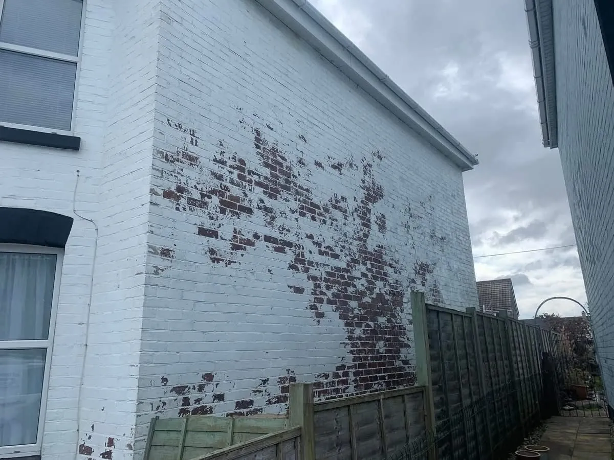 Peeling paint on a brick wall before redecoration in Honiton