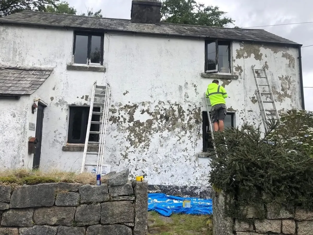Cottage with blown, flaking render before repair in Honiton